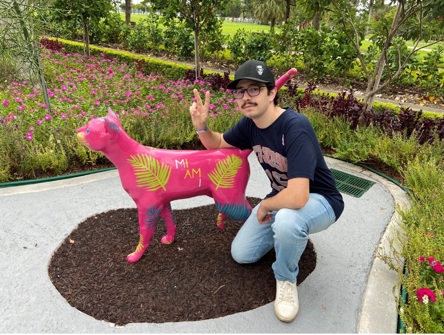 Nicholas Cagliuso posing with an artistic pink cat statue in Miami