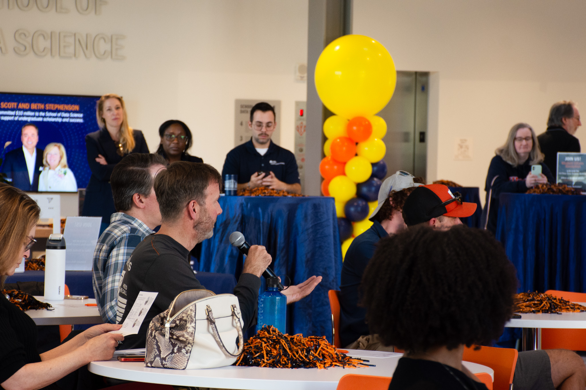 An audience member in the capitol one hub holds a microphone to ask a question of the panel