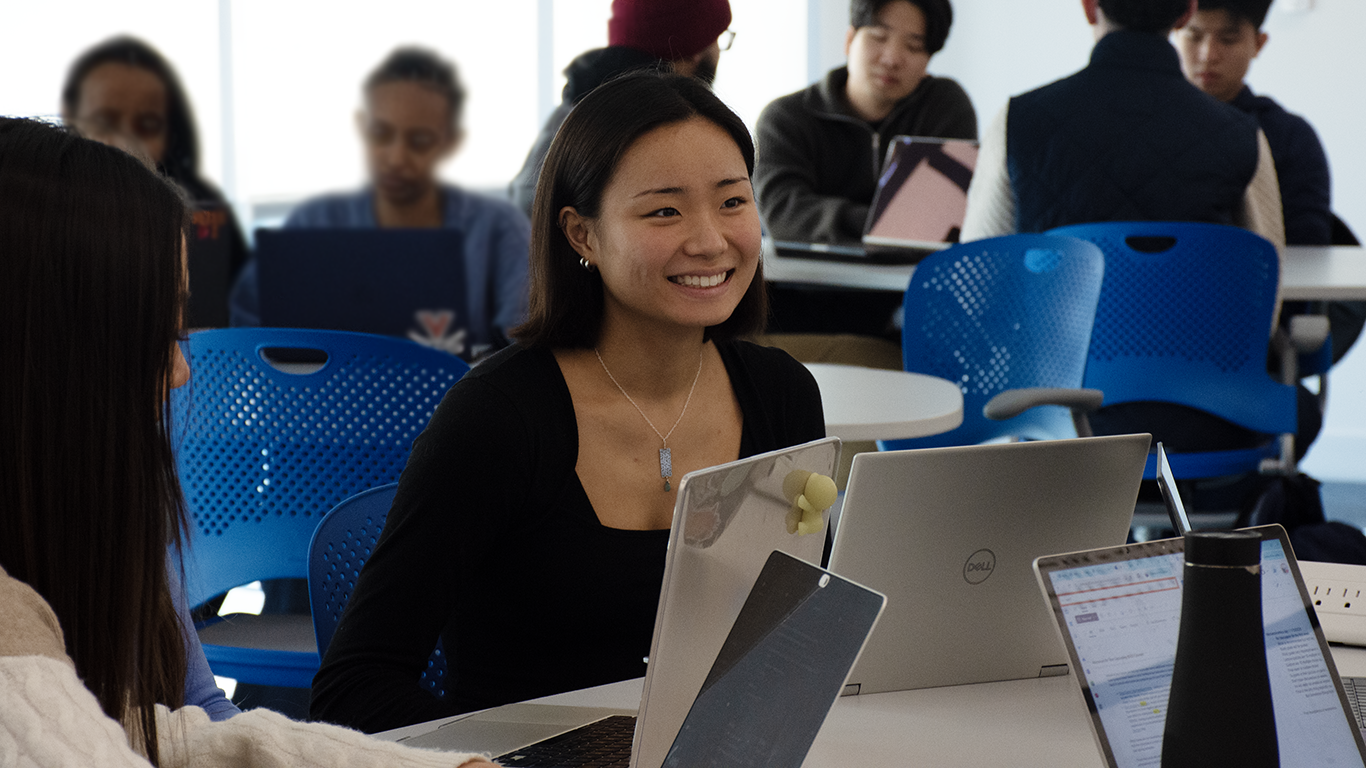 UVA Data Science BSDS student Jia Park in the classroom with students and laptops