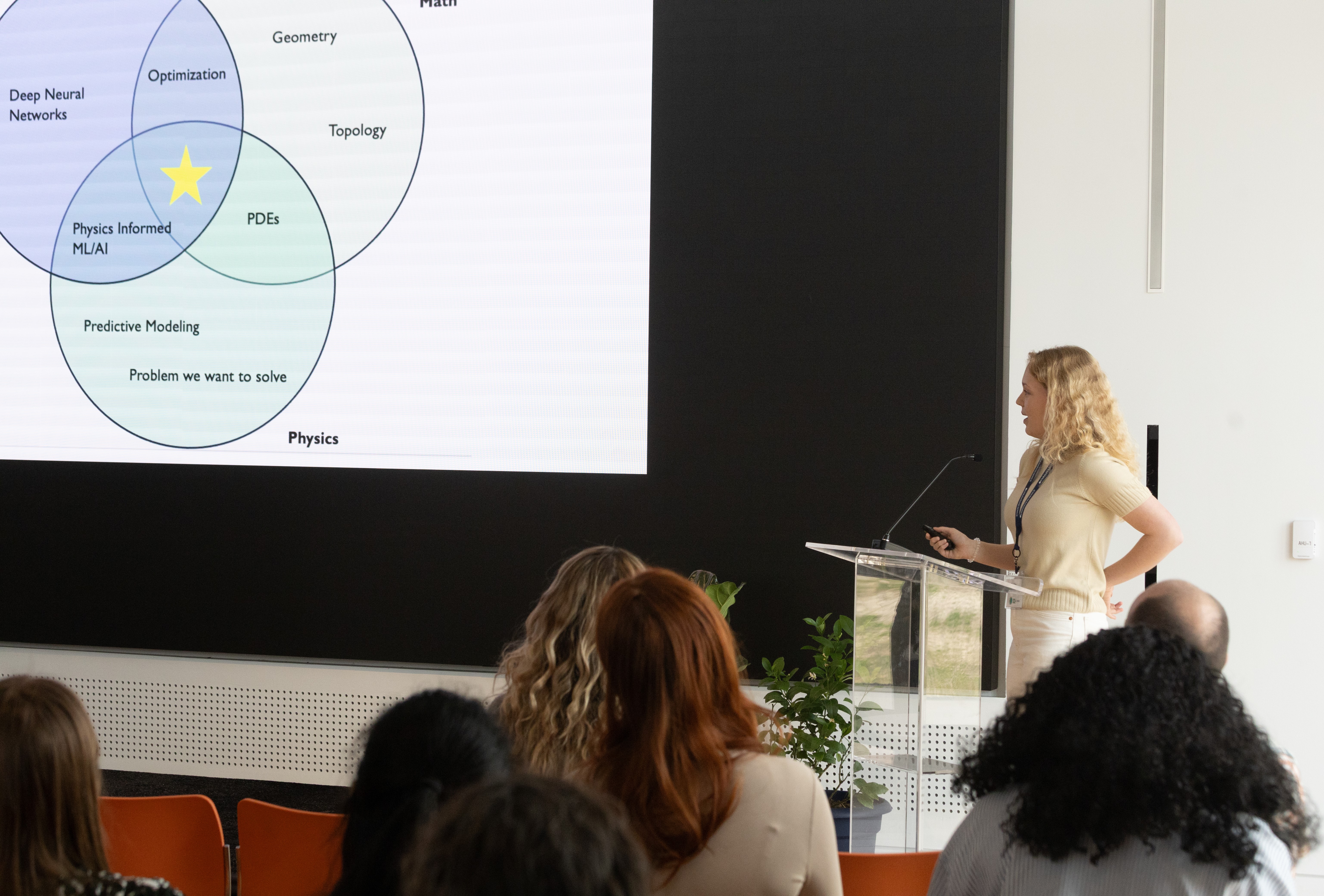 Ph.D. student Zoë Gray, standing at the podium, presents on her research.