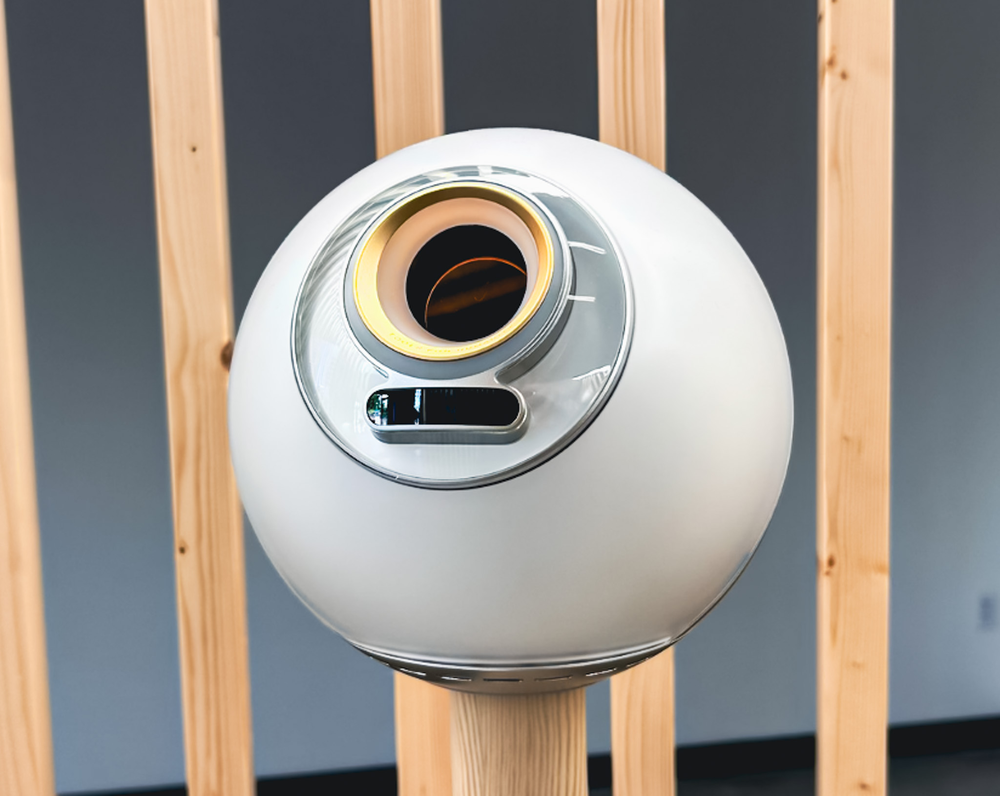 A large white orb in front of a wooden structure.