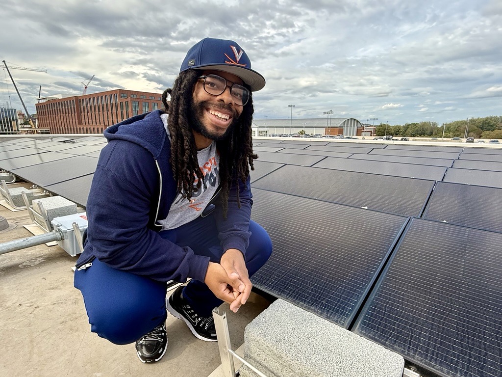 Shiraz Robinson poses with solar panels atop the School of Data Science