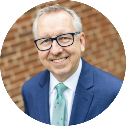 Richard Chylla in coat and tie with glasses, professional headshot circle crop