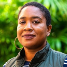 Jasmine McNealy headshot outdoors with green garden background