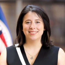 Erie Meyer headshot with American flag in background