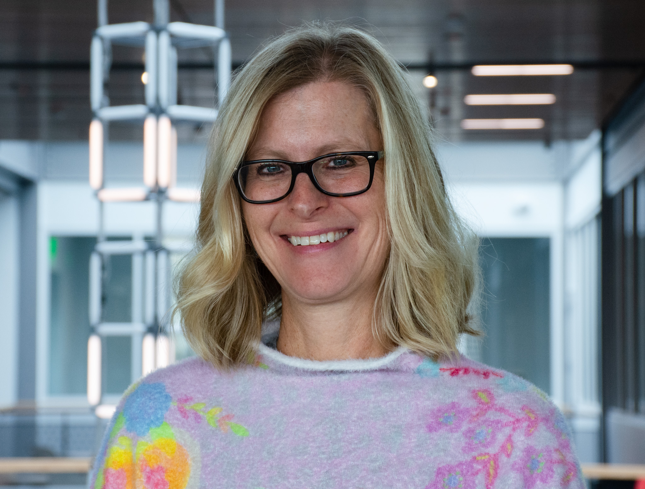 Beth Wright headshot in front of a lit up data sculpture inside of the School of Data Science.