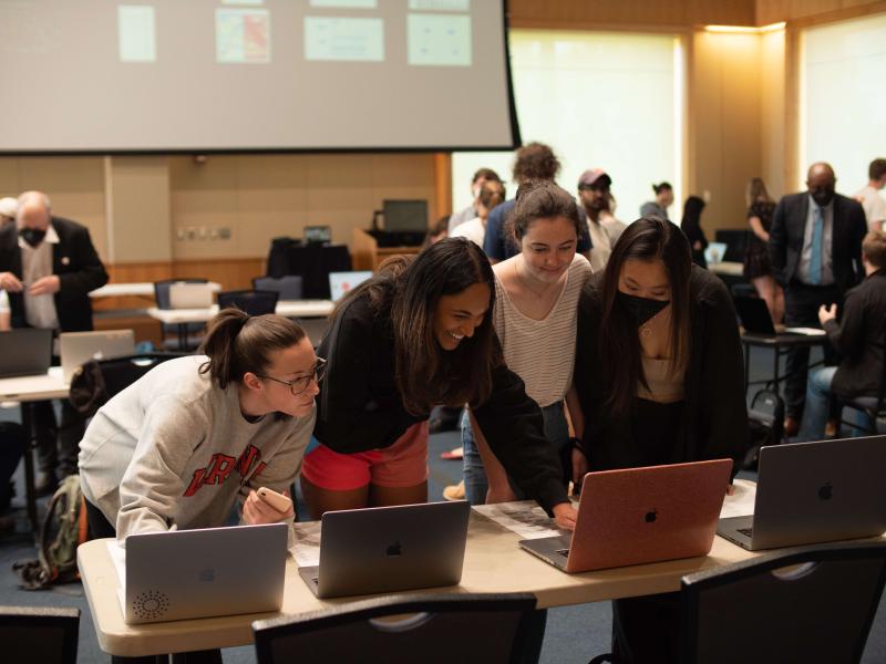 four female students around laptops