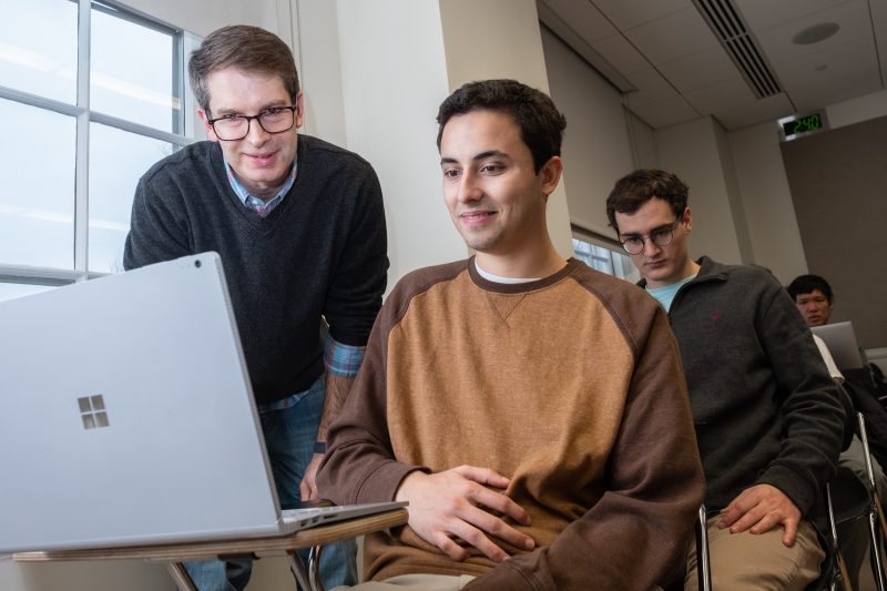 students working around laptop