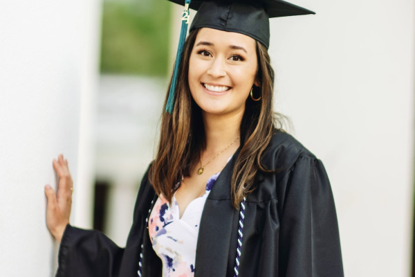 Hannah Koizumi in cap and gown on graduation day UVA Rotunda