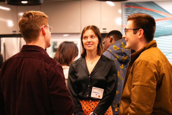 Three students and alumni network at a career event