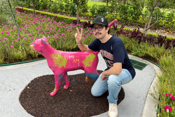 Nicholas Cagliuso posing with an artistic pink cat statue in Miami