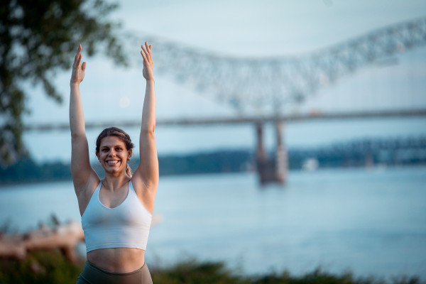 UVA Data Science online student Hallie Parten in yoga pose outside with bridge in background