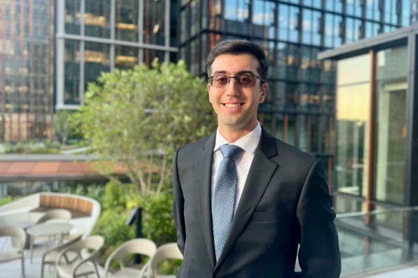 UVA Data Science MSDS online student Timothy Rodriguez standing outside in a business suit and tie