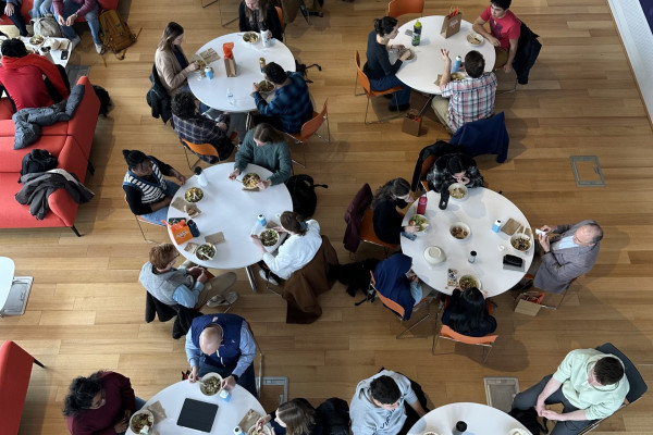 Overhead view of students and professionals participating in a roundtable lunch.